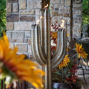 Steel Saguaro Cactus Torch with flames lit, on back porch