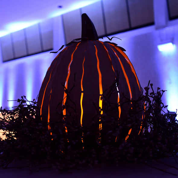 Tall Pumpkin Luminary lit up outside at night